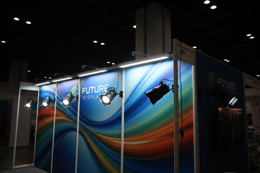 LED trade show display lights illuminating booth backdrop with light bars and spotlights mounted on display frames in dark exhibition hall